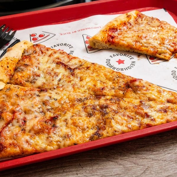 Two cheese pizza slices on a red tray with plastic cutlery and branded paper.